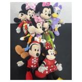 Group of Mickey Minnie and goofy plushies.