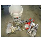 Bucket full of wine-making supplies;