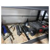 Assortment of grease guns in an oil container