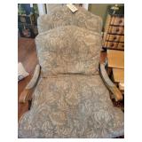 Overstuffed chair with wooden carving