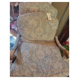 Overstuffed chair with wooden carving