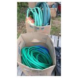 2 boxes of garden hoses and water buckets