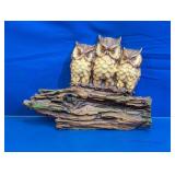 Three Owls Perched on a Rustic Log