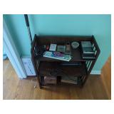 Three-Tier Wooden Display Shelf with Assorted Household Items and Electric Cleaning Brush