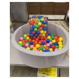 A GREY FOAM BALL PIT WITH BALLS
