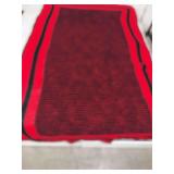 This is a handmade red and black crochet throw blanket.