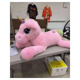 A PLUSH PINK UNICORN TOY WITH A RAINBOW COLORED TAIL AND HORN