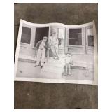 A SIGNED- VINTAGE BLACK AND WHITE PRINT DEPICTING THREE PEOPLE OUTSIDE A WOODEN BUILDING-