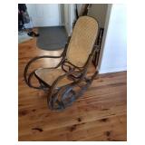 Antique bent wood rattan rocker has a stain on