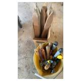 Bucket of gardening hand tools and wooden spikes