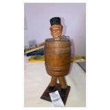 Carved wooden man in a barrel jar 8" tall