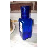 Cobalt blue glass Wyeth medicine bottle with cup