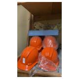 10 orange hard hats and tray of safety goggles
