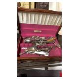 Various pieces of flatware in wooden case