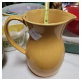 Yellow pottery milk pitcher