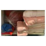 Shelf lot of bath towels and sleeping bag
