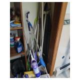 Corner lot of Swiffers, dusters, ironing board
