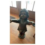 Plastic garden statue of a child with open arms