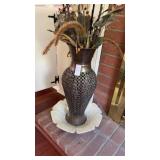 Decorative metal vase on white floral shaped tray