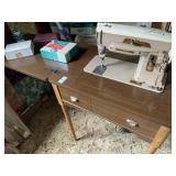 Singer sewing machine/ table with attachments,
