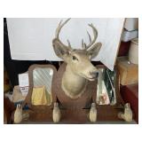 Deer head mount on a wooden hall rack with hooves