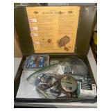 Green box with miscellaneous items and Model