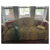 Vintage yellow floral sofa with throw pillows and