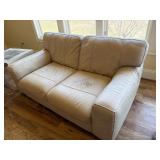 Cream Two-Seat Sofa with Visible Wear