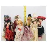 7 dolls fancy dresses on stands