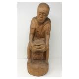 Large wood carving of old man laboring