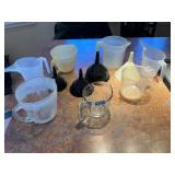 Assorted glass and plastic mixing cups and funnels