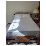 Full size bed with bedding and pillows