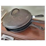 Three cast-iron skillets - one with lid