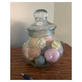 Covered glass jar with balls inside