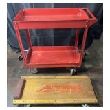 Red metal utility cart and Auto Works automotive