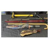 Group of walking sticks, bike pump and umbrellas