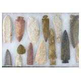 14 Native American arrowheads in display case,