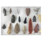 17 Native American arrowheads in display case,