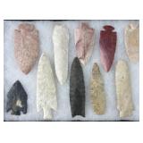 10 Native American arrowheads in display,