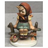 Hummel figurine girl sitting on fence