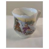 Hand painted teacup of kids sledding