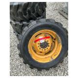 4 skid steer tires and rims from a 555 New Holland skid steer