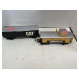2 train cars.  CAT. CATERPILLAR.
