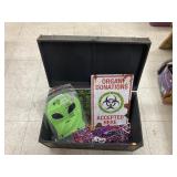 Metal signs, alien masks, & necklaces in trunk
