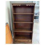 Smaller wooden bookshelf with scalloped top edge…..24 x 10-1/2 x 48 tall…..has bottom drawer as well