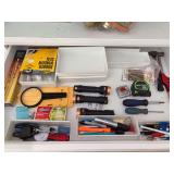 Contents of top kitchen drawer…..Duracell flashlights, tape measures, hammer, small white drawer organizers and more