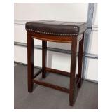 Solid wood base stool with brown faux leather saddle seating…..17 x 12 x 26-1/2 tall