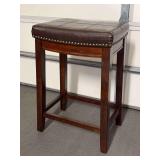 Solid wood base stool with brown faux leather saddle seating…..17 x 12 x 26-1/2 tall