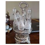 Antique silver-plated castor with etched glass cruet set. Missing one stopper. Approx 15 in tall.