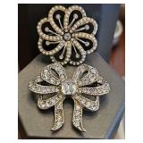 Two Monet brooches.